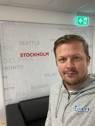 Patrik från Tintry framför Stockholm-skylt